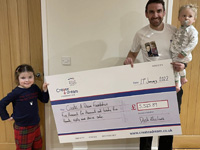 Dosh holding a large cheque